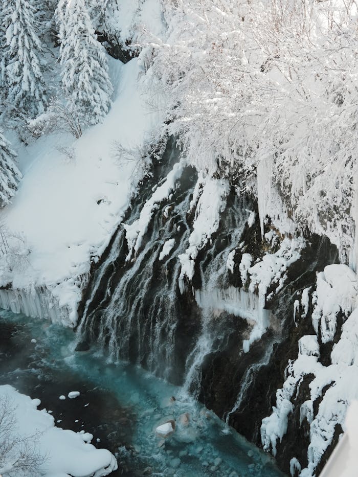 Stunning view of snow-covered waterfall in Hokkaido, Japan during winter, capturing the serene icy beauty.